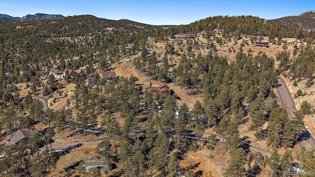 drone / aerial view featuring a forest view and a mountain view