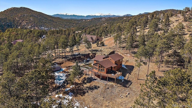 birds eye view of property with a mountain view and a wooded view