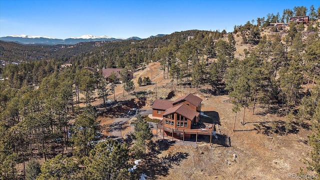 drone / aerial view featuring a forest view and a mountain view