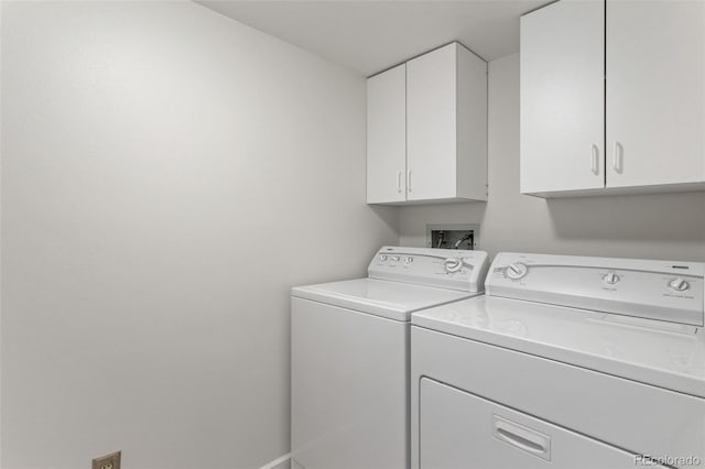 clothes washing area with cabinets and washing machine and dryer