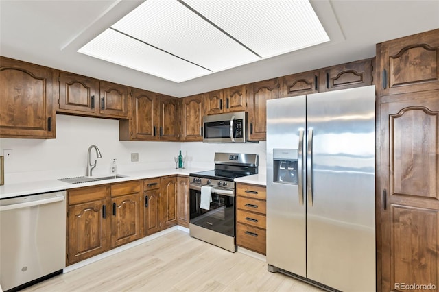 kitchen featuring sink, light wood-type flooring, and appliances with stainless steel finishes