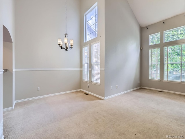 5155 W Quincy Ave Unit J103, Denver, CO 80236 - unfurnished room with high vaulted ceiling, a chandelier, healthy amount of natural light, and light colored carpet