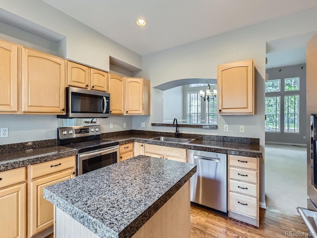 5155 W Quincy Ave Unit J103, Denver, CO 80236 - kitchen featuring stainless steel appliances, light brown cabinetry, arched walkways, recessed lighting, and a chandelier