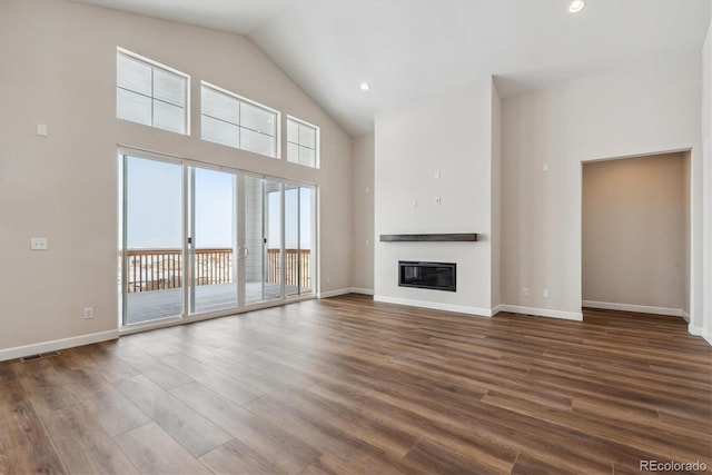 unfurnished living room with a high ceiling and dark hardwood / wood-style floors