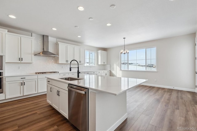 kitchen featuring sink, white cabinets, wall chimney range hood, and appliances with stainless steel finishes