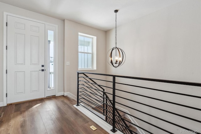 foyer with dark hardwood / wood-style floors and an inviting chandelier