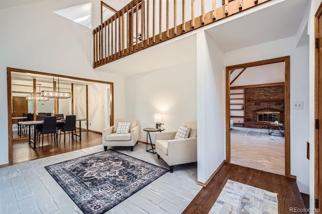 6545 Grey Eagle Ln, Colorado Springs, CO 80919 - living area with a towering ceiling, wood finished floors, a fireplace, baseboards, and a chandelier