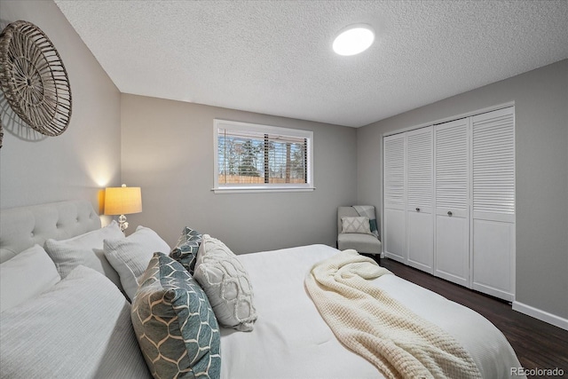 bedroom featuring a closet, dark wood-type flooring, and a textured ceiling