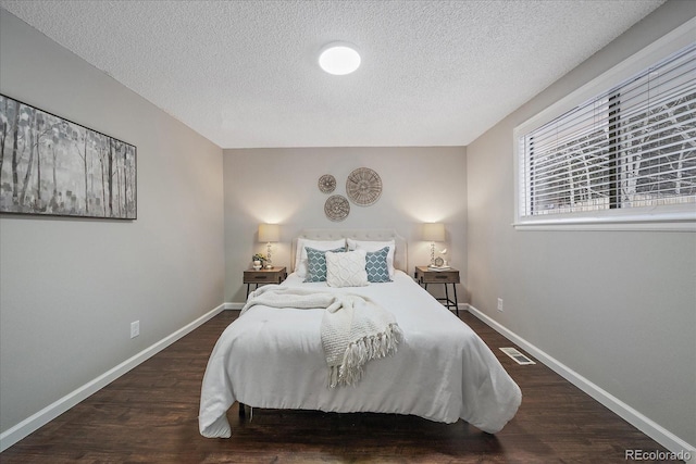 bedroom featuring dark hardwood / wood-style floors and a textured ceiling