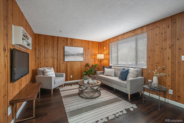 living room featuring wood walls, dark hardwood / wood-style flooring, and a textured ceiling