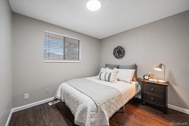 bedroom featuring a textured ceiling and dark wood-type flooring