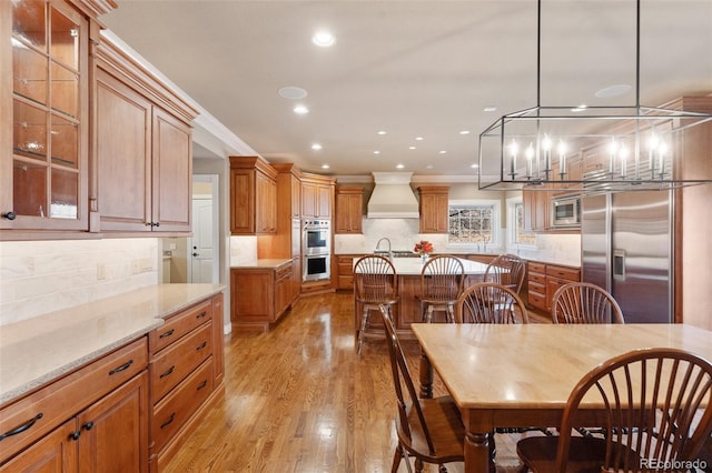 dining room featuring a notable chandelier, light wood-type flooring, and crown molding