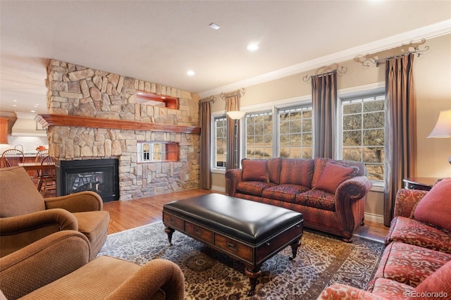 living room featuring crown molding, a fireplace, and hardwood / wood-style flooring