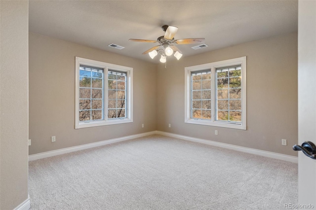 empty room featuring light carpet, plenty of natural light, and ceiling fan