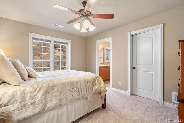 carpeted bedroom featuring ceiling fan and ensuite bath