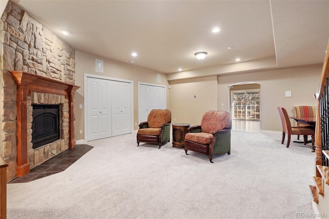 sitting room featuring a fireplace and dark colored carpet