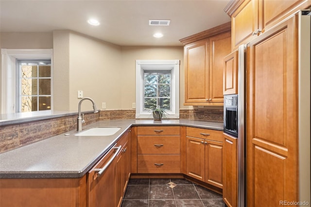 kitchen with kitchen peninsula, sink, dark tile patterned floors, and paneled refrigerator