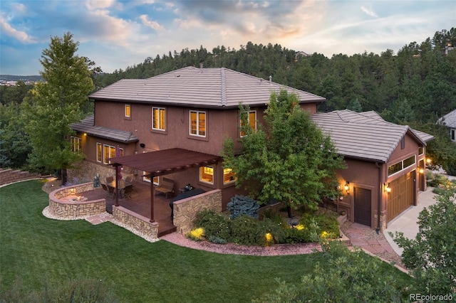 exterior space featuring a fire pit, a garage, a patio, and a front lawn