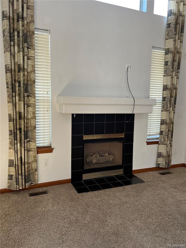 interior details with carpet and a tiled fireplace