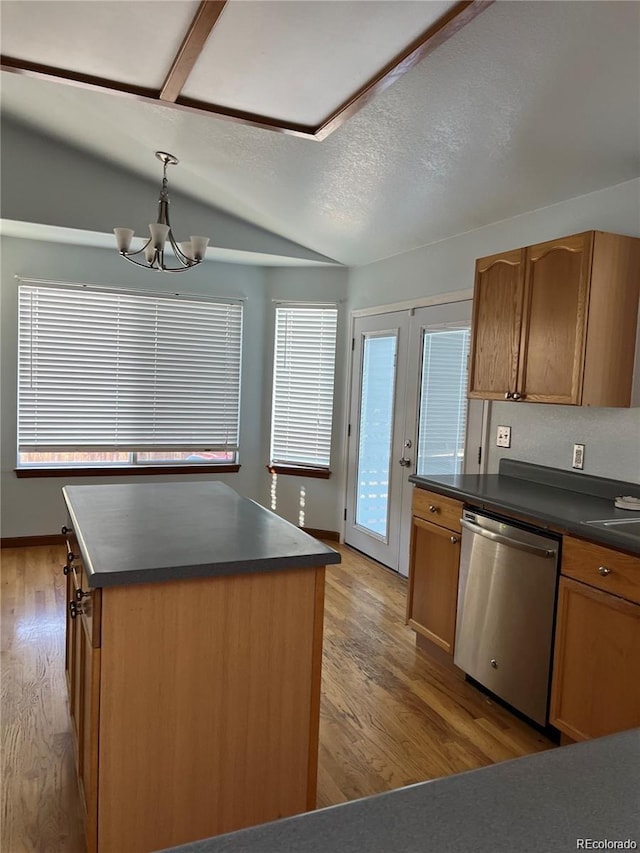 kitchen featuring pendant lighting, a kitchen island, stainless steel dishwasher, and light hardwood / wood-style floors