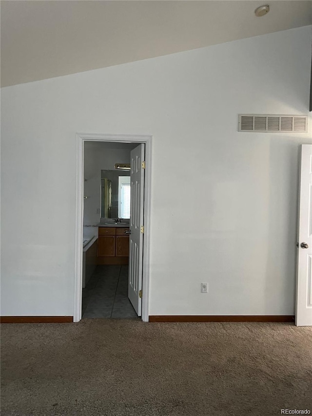 carpeted empty room with vaulted ceiling