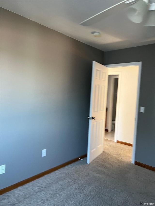 unfurnished room featuring ceiling fan and carpet floors