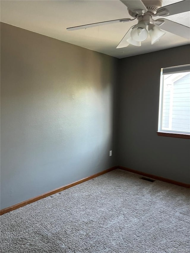 carpeted spare room with ceiling fan