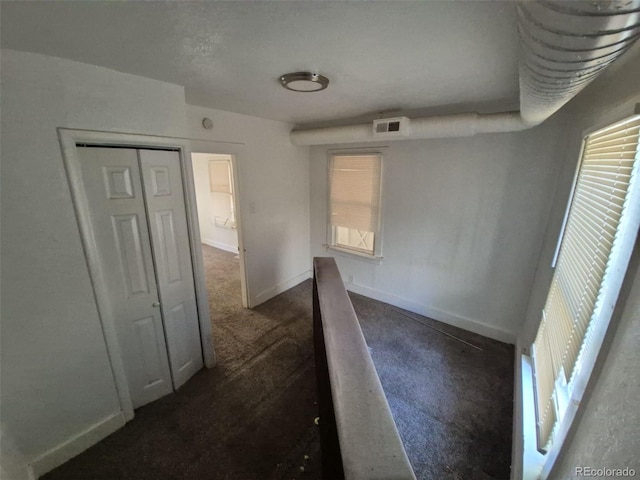 1272 N Ulster St, Denver, CO 80220 - hallway featuring dark carpet and baseboards