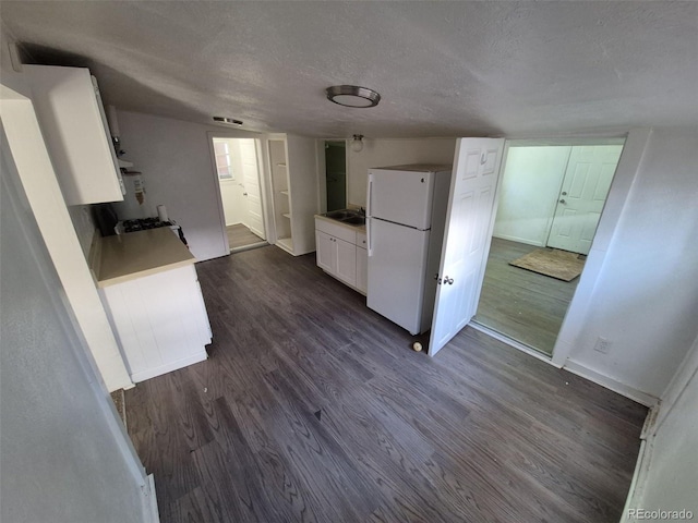1272 N Ulster St, Denver, CO 80220 - kitchen with freestanding refrigerator, a textured ceiling, white cabinets, dark wood-style floors, and baseboards