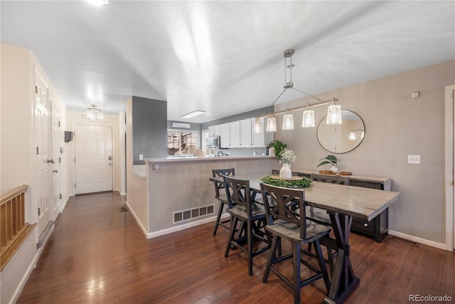 dining area featuring a textured ceiling and dark hardwood / wood-style flooring