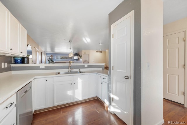 kitchen with stainless steel dishwasher, dark hardwood / wood-style flooring, kitchen peninsula, and sink