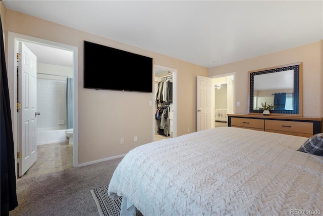 carpeted bedroom with ensuite bath, a spacious closet, and a closet