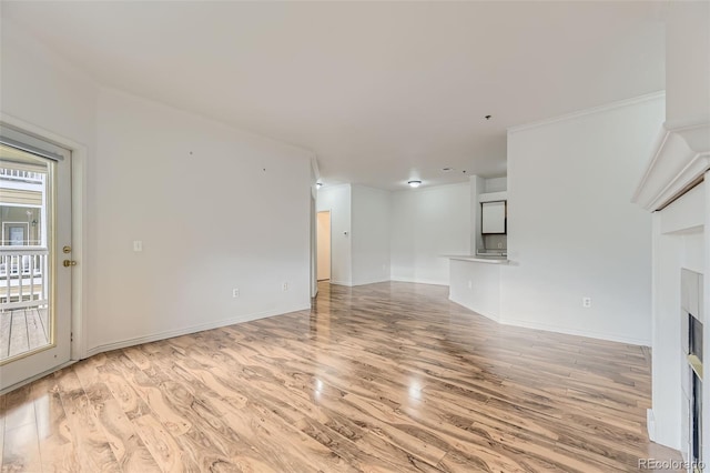 unfurnished living room with ornamental molding and light hardwood / wood-style flooring