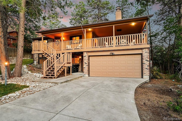 view of front of house featuring concrete driveway, an attached garage, brick siding, and stairs