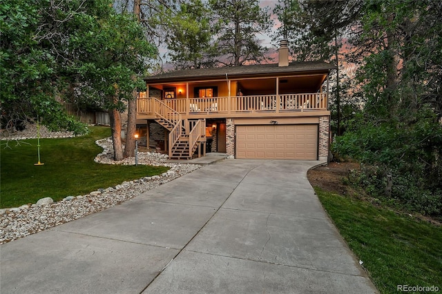 view of front facade with stairway, driveway, a porch, a front yard, and a garage