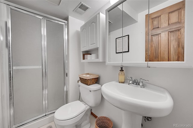 bathroom with toilet, a shower stall, and a sink