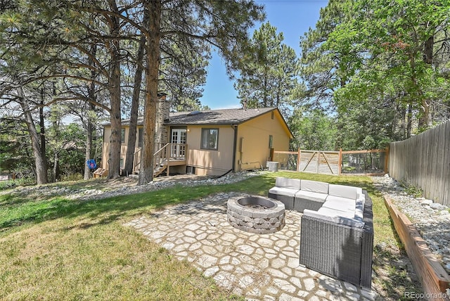 back of property with a patio area and an outdoor living space with a fire pit