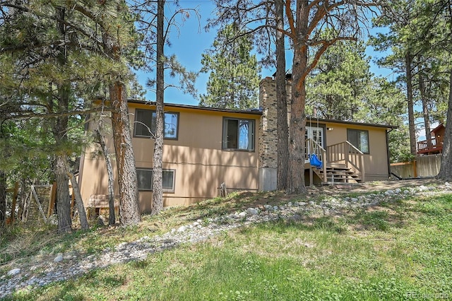 back of house with a chimney and fence