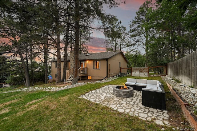 rear view of house featuring a patio and an outdoor living space with a fire pit
