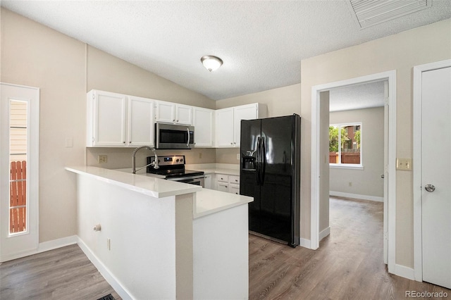 8401 Sandreed Cir, Parker, CO 80134 - kitchen featuring stainless steel appliances, a peninsula, white cabinets, light countertops, and vaulted ceiling