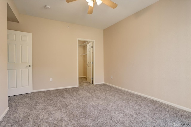 unfurnished bedroom with ceiling fan, light colored carpet, a closet, and a walk in closet