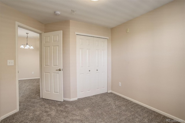 unfurnished bedroom featuring dark carpet and a closet