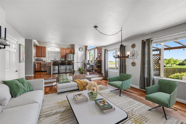 16863 Trail View Cir, Parker, CO 80134 - living area featuring wood finished floors, a textured ceiling, and a chandelier