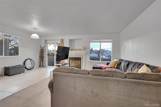 living room featuring plenty of natural light, light carpet, and a tile fireplace