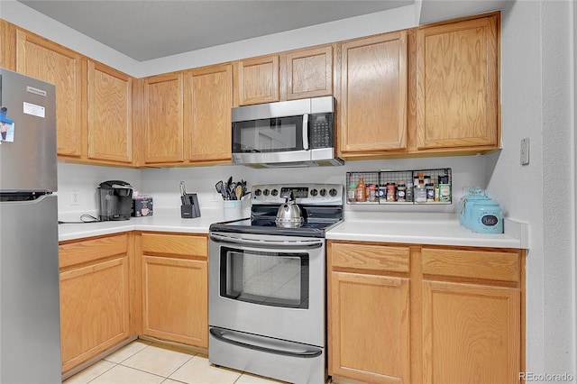 kitchen featuring appliances with stainless steel finishes, light brown cabinetry, and light tile patterned flooring