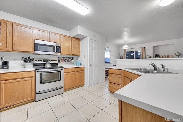 kitchen featuring light tile patterned flooring, appliances with stainless steel finishes, a textured ceiling, and sink