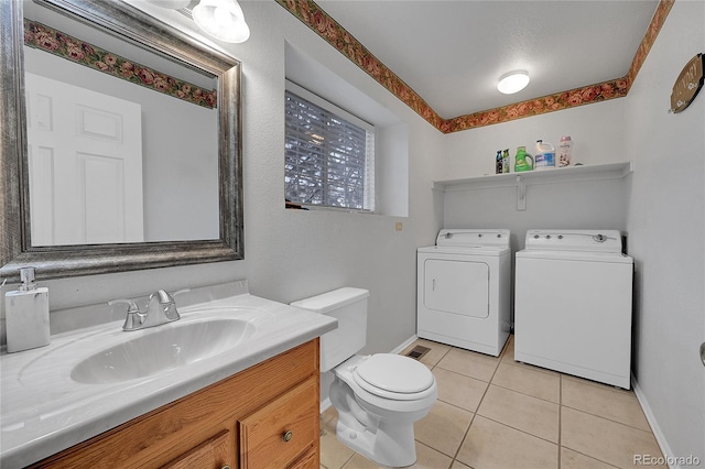 bathroom featuring tile patterned floors, washer and dryer, toilet, and vanity