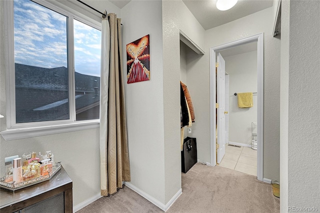 hallway featuring light colored carpet