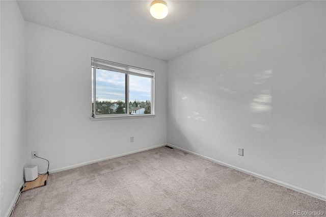 spare room featuring carpet floors and vaulted ceiling