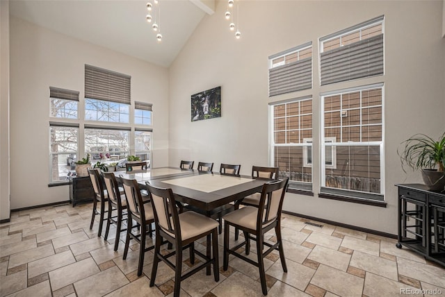 dining space featuring high vaulted ceiling